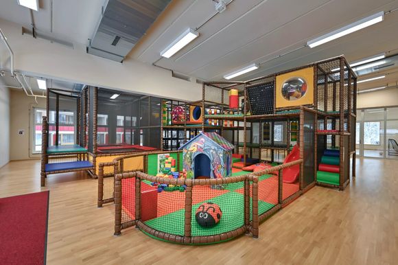Indoor-Spielplatz mit Klettergerüst, Rutsche und Spielhaus