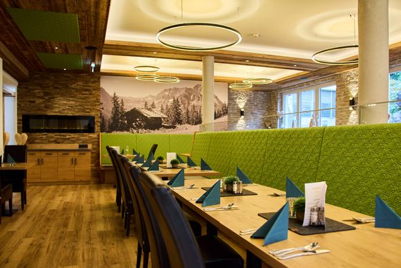 Restaurantbereich mit grünen Sitzbänken und Holzdetails