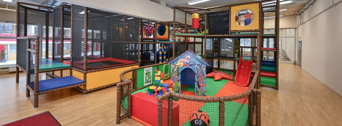 Indoor-Spielbereich mit Klettergerüst, Trampolin und Rutsche
